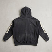 Creeping Panel Vintage Washed Frayed Hoodie in washed black, back view with sleeve patches, laid flat on a light surface