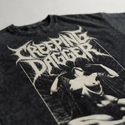 Close-up of the Suffering Moon tee's cream Creeping Dagger logo and seated-figure print on washed black fabric
